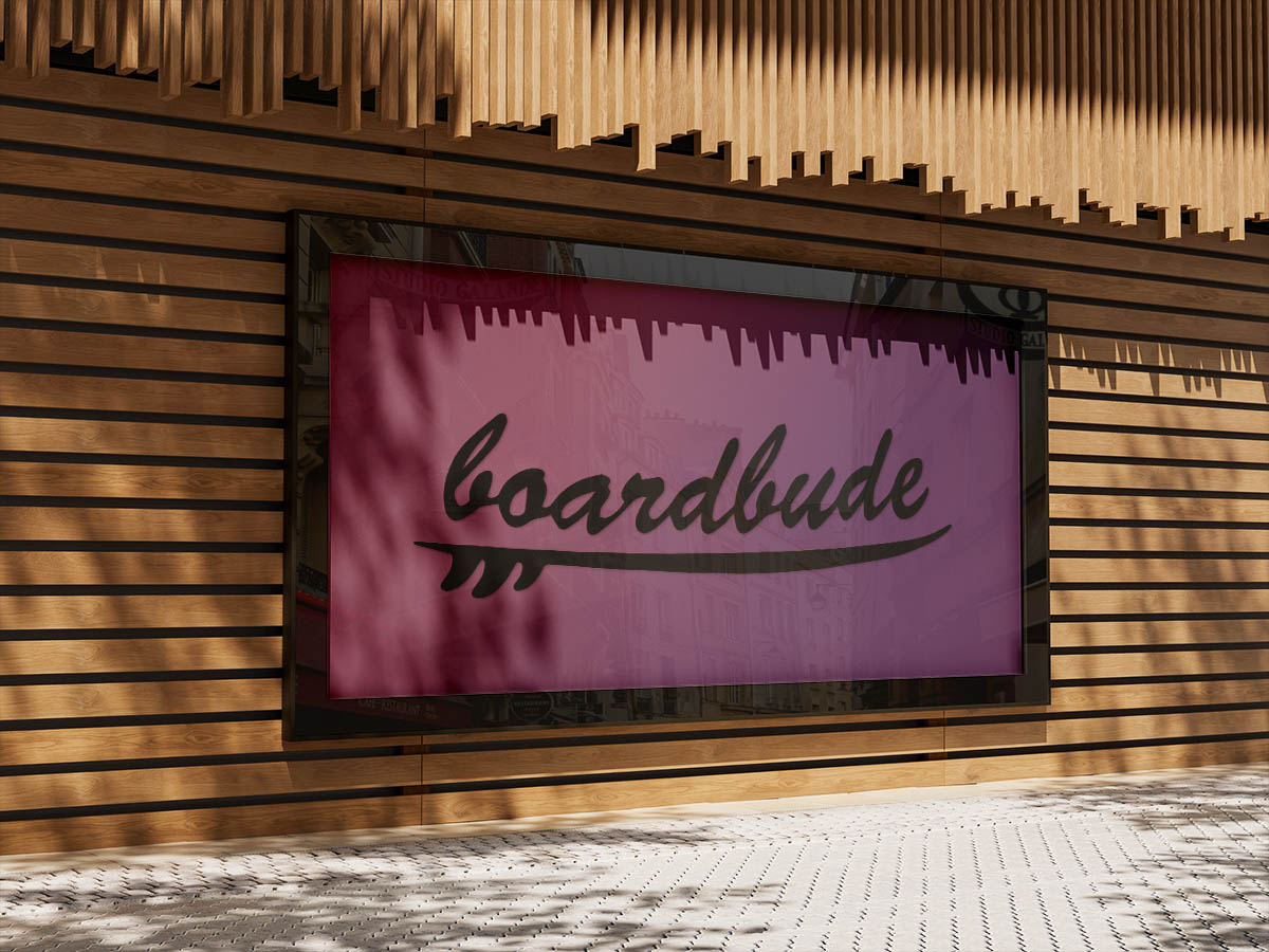 Das Logo ist als großes Poster in einem schwarzen Holzrahmen an einer Holzwand montiert