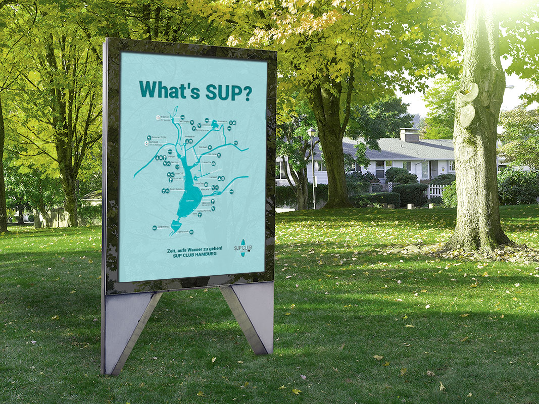 Im grünen stehendes Plakat mit der Aufschrift Whats's SUP